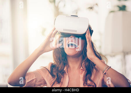 Amazed woman looking in a VR goggles and gesturing Stock Photo