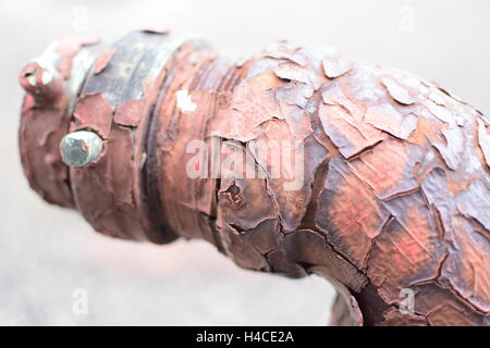 Back of Old Weathered Rusty Drainage Pipe Valve with Peeled Red Paint Stock Photo