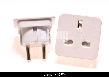 Travel plug adapter - for using a three pin UK plug in a two pin European socket Stock Photo