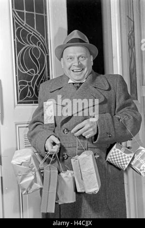 Der deutsche Schauspieler Ludwig Schmitz mit Geschenken, Deutschland 1930er Jahre. German actor Ludwig Schmitz with presents, Germany 1930s Stock Photo