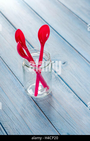 plastic spoons carmine on blue background Stock Photo
