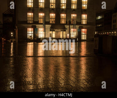 reflection of illuminated windows on wet street in the city Stock Photo