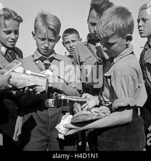 Hitlerjungen bei der Brotausgabe im Hitlerjugend Lager, Österreich 1930er Jahre. Hitler youths getting fresh bread and chocolate at the Hitler youth camp, Austria 1930s. Stock Photo