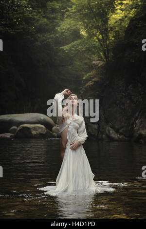 Beautiful woman posing in dreamy mountain stream. Fantasy and surreal Stock Photo