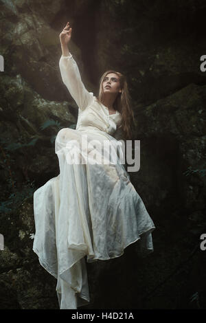 Woman posing on forest rocks. Dreamy atmosphere Stock Photo