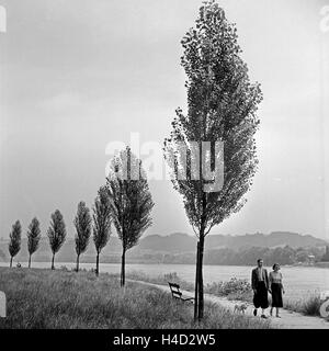 Ein junges Paar spaziert am Ufer der Donau bei Passau entlang, Deutschland 1930er Jahre. A young couple strolling on the sore of river Danube near Passau, Germany 1930s. Stock Photo