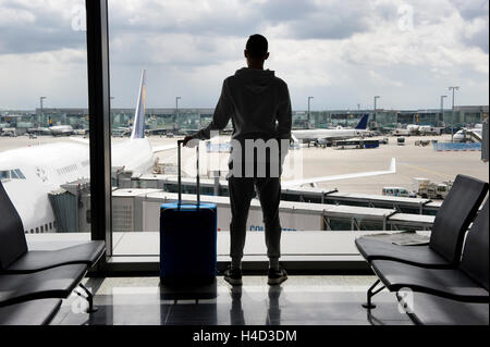 A teenager is waiting on an airport for departure Stock Photo
