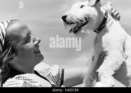 Porträt einer jungen Frau mit ihrem Hund, Deutschland 1930er Jahre. Portrait of a young woman with her dog, Germany 1930s. Stock Photo