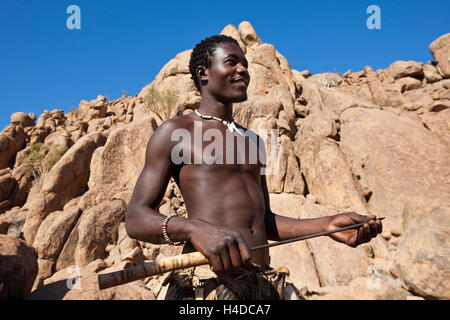 African hunter from Damara people stays near the hut in the village in Namibia, South Africa Stock Photo