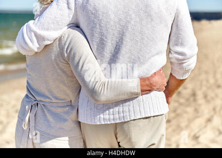 close up of happy senior couple hugging on beach Stock Photo