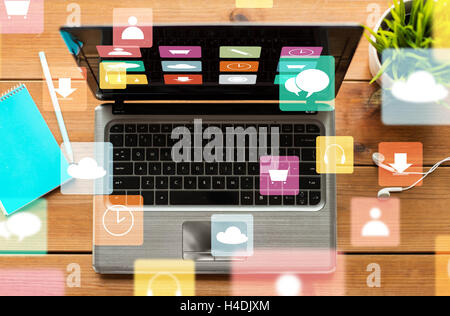 close up of laptop on wooden table with menu icons Stock Photo