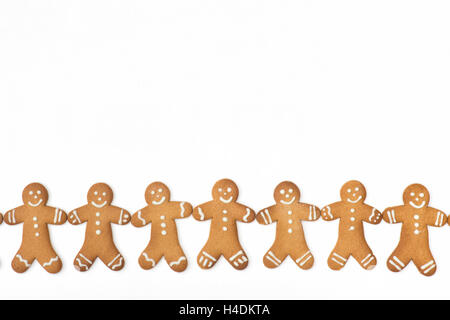 Gingerbread Men biscuits in a line on a white background Stock Photo