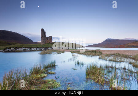 The ruins of Ardvreck Castle on the shores of Loch Assynt under a full moon on a cold Winter's night in Scottish highlands Stock Photo