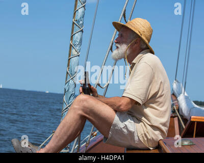 Older man on his sailing ship Stock Photo