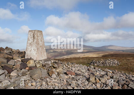 Summit cairn trig point at Windy Gyle up amongst the Cheviot Hills on a blustery early Autumn, bright sunny day Northumberland Stock Photo