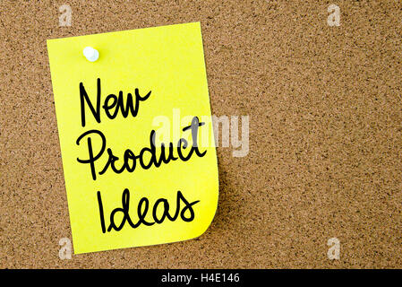 New Product Ideas text written on yellow paper note pinned on cork board with white thumbtack. Business concept image Stock Photo