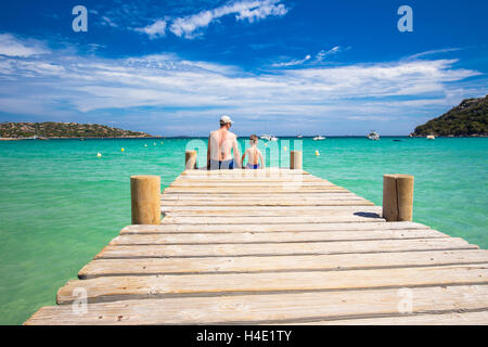 Father and his little son enjoying sea on Santa Giulia beach with tourquise clear water and pine trees, Corsica, France Stock Photo