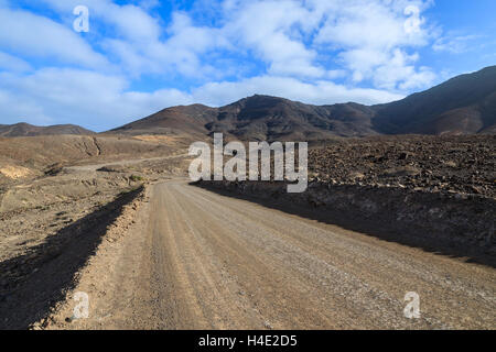 Unpaved road to Cofete beach from Morro Jable town and volcanic mountains in background, Fuerteventura, Canary Islands, Spain Stock Photo