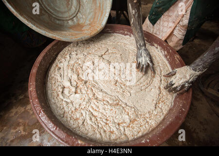 Employees work to manually churn shea butter at a fair trade production facility in Réo, Burkina Faso. Stock Photo