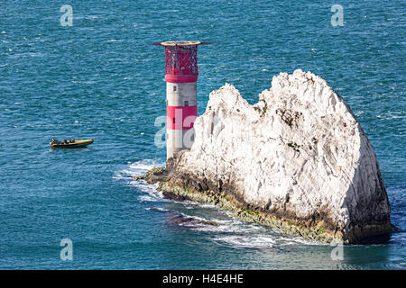 Boat rounding the lighthouse on the tip of the Needles, Isle of Wight, UK Stock Photo