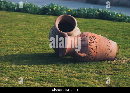 Two Clay amphora jug, old ceramic vases on green grass lawn near sea Stock Photo