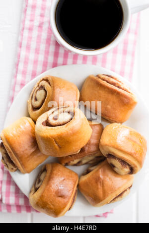 Mini cinnamon buns and coffee. Top view. Stock Photo