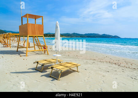 Sunchairs and lifeguard tower on white sand beach in Porto Giunco bay, Sardinia island, Italy Stock Photo