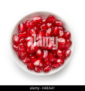Bowl of pomegranate seeds isolated on white background, top view Stock Photo