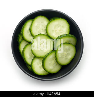 Black bowl of fresh cucumber slices isolated on white background, top view Stock Photo