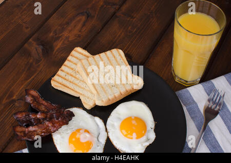 Fried eggs with toast and bacon Stock Photo