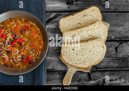 Chilli con carne with fresh bread on wood