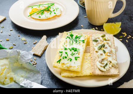 Crisp Crispbread with curd cheese spread with chives and seeds, fried egg and morning tea Stock Photo