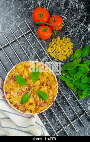 Baked homemade pasta with leeks, bacon and cream, spinach and fresh tomatoes from the garden Stock Photo
