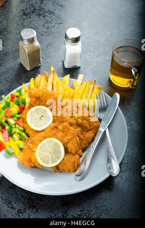 Schnitzel with french fries, homemade, platter, czech beer, vegetable, lemons Stock Photo