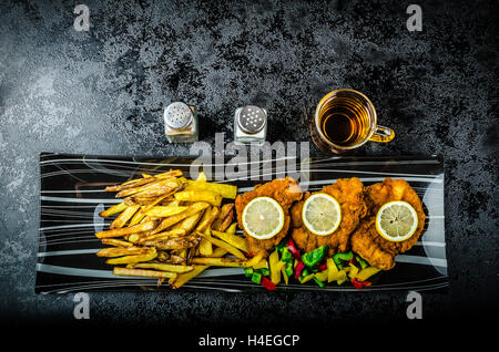 Schnitzel with french fries, homemade, platter, czech beer, vegetable, lemons Stock Photo