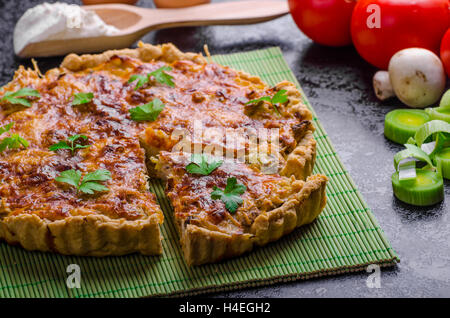 Home French cake stuffed with mushrooms, tomato and leek and ingredience together Stock Photo