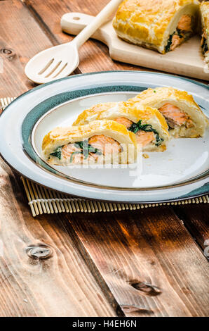 Salmon baked in puff pastry with spinach and garlic Stock Photo