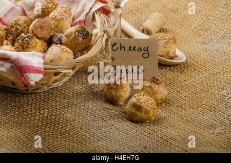 Cheesy bites with seeds, wine in wicker basket, nice gift Stock Photo