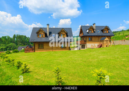 PIENINY MOUNTAINS, POLAND - JUN 10, 2014: Traditional wooden mountain house on green field in summer, Szczawnica, Pieniny Mountains, Poland. Most houses are built from wooden logs in this area.