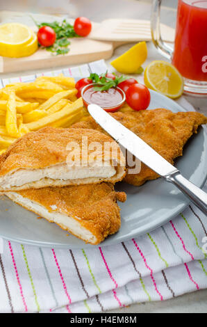 Schnitzel with french fries and a spicy dip, fresh from red orange Stock Photo