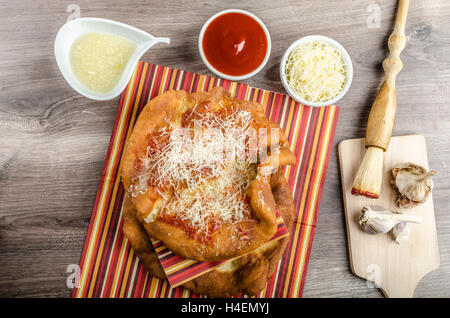 Traditional carnival fast food specialty, fried yeast dough with cheese, ketchup and garlic Stock Photo