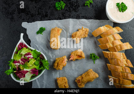 Salmon in herb batter with spicy dressing - fish and chips without fat chips with mixed salad with endive and czech beer Stock Photo