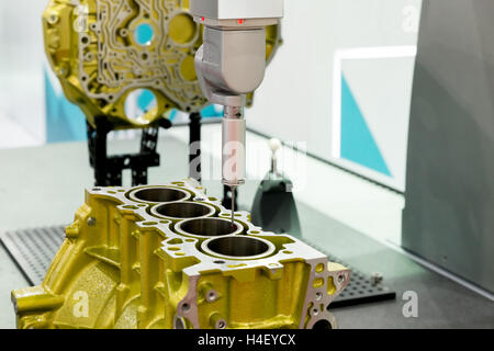 5-axis measurement probe is measuring the cylinder block working in factory Stock Photo