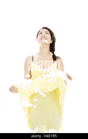 Woman catching feathers with her yellow dress Stock Photo