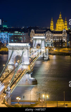 Night view of the Szechenyi Chain Bridge over Danube River and church St. Stephen's Basilica in Budapest, Hungary. Stock Photo