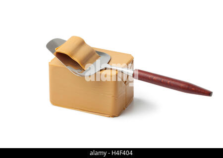 Piece of norwegian flotemysost cheese and slicer on white background Stock Photo