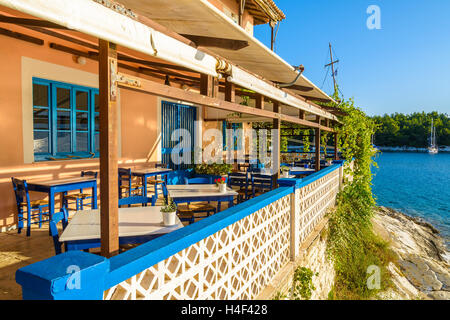 Blue chairs with tables in traditional Greek tavern in Fiskardo port, Kefalonia island, Greece Stock Photo