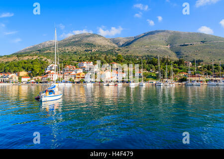 Yacht boat on blue sea and view of Agia Efimia fishing village with port, Kefalonia island, Greece Stock Photo