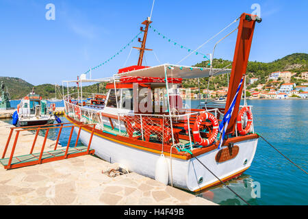 VATHI PORT, ITHAKA ISLAND, GREECE - SEP 19, 2014: Tourist boat in port of Vathi on Ithaka island. Daily cruises from Kefalonia island are popular among tourists spending vacation on Greeks islands. Stock Photo