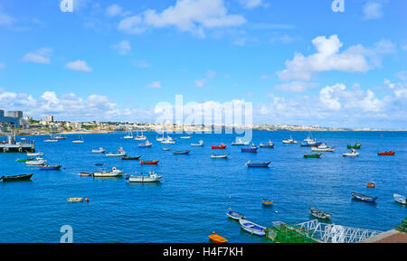 The colorful fishing boats dance on the waves at the shore of Ribeira beach of Cascais, Portugal. Stock Photo